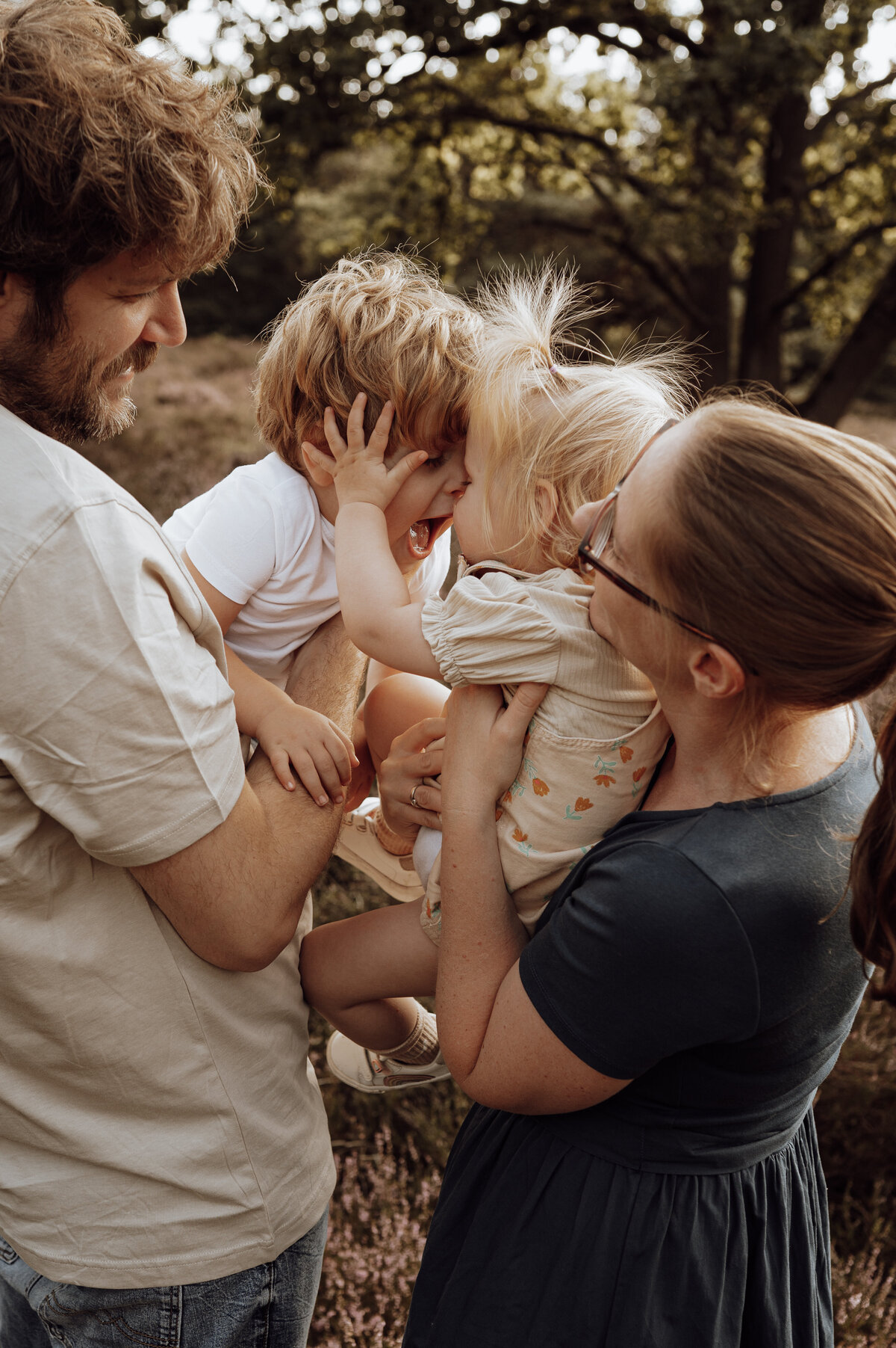 Gezin speelt tijdens familie fotoshoot in het bos