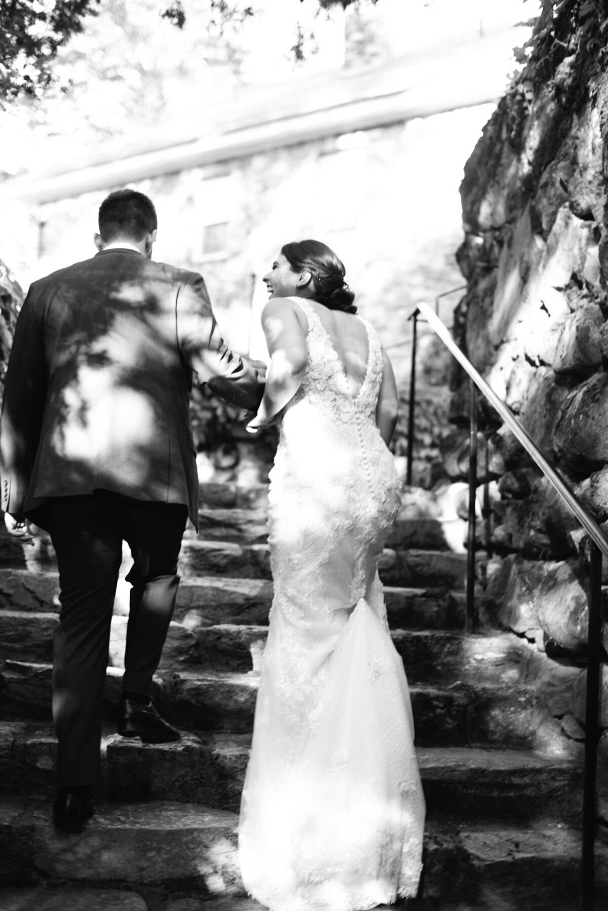 bride and groom walking up stone steps
