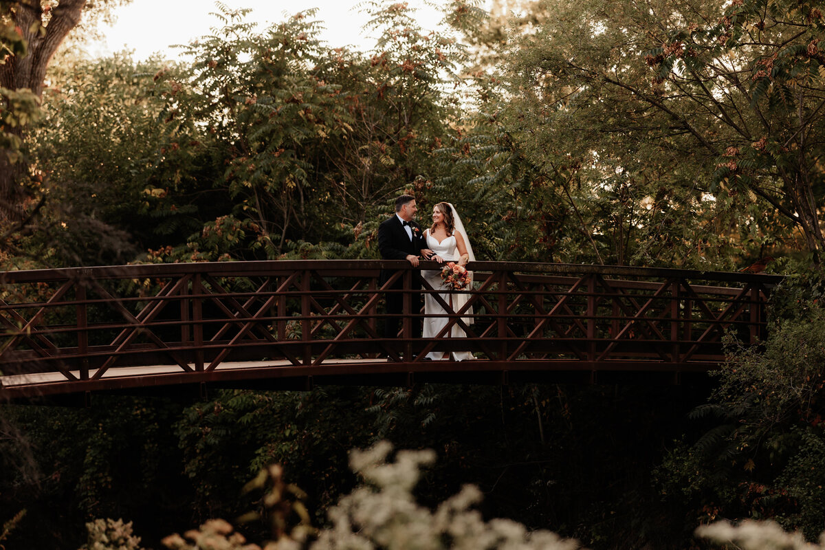 A wedding couple snuggles on a bridge in downtown Lockport Il.