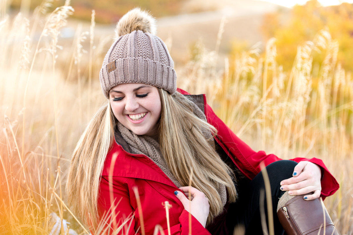 senior girl looks off camera candidly during fall senior session at snowbasin