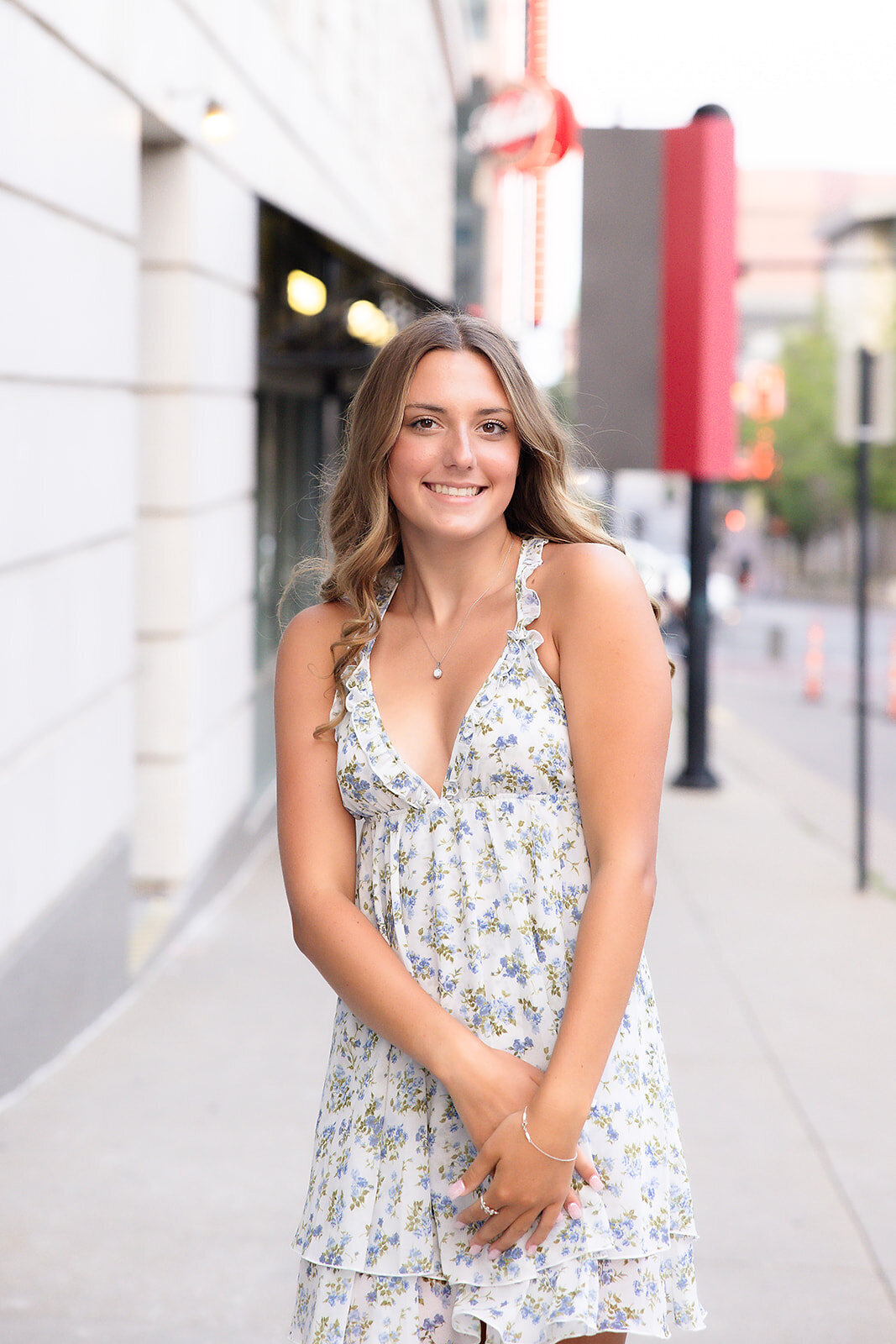 Girl on street smiling with hands together
