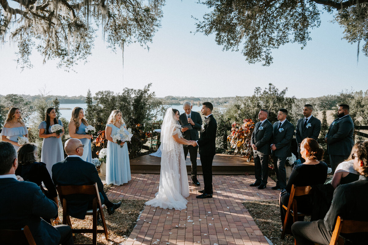 outdoor wedding ceremony with the bride and groom at the altar, overlooking a beautiful lake