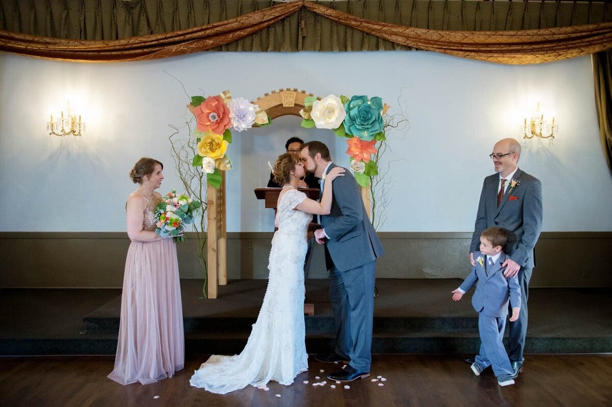 a bride and groom kiss during their wedding ceremony at polaris hall