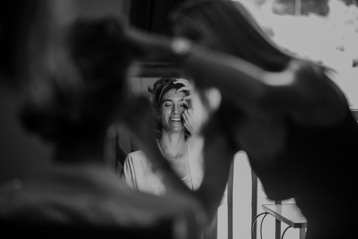 A person gets their makeup done on their wedding day.