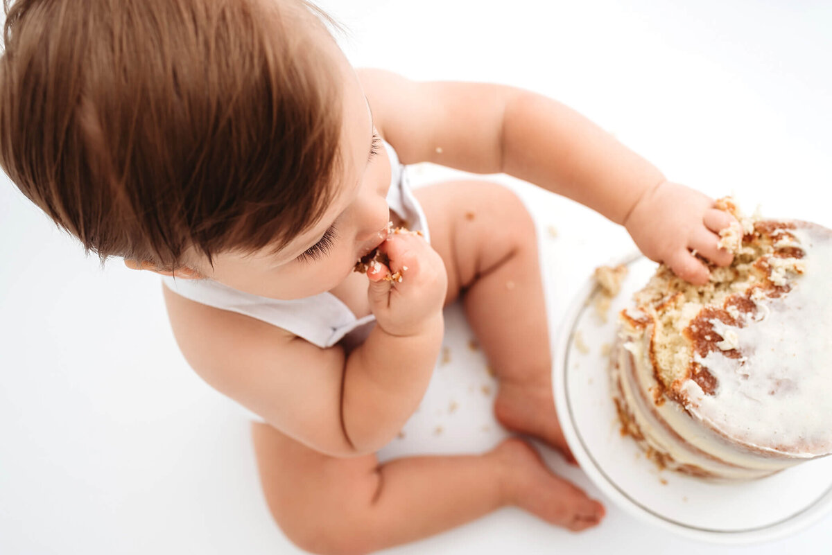 baby eating cake at one year denver milestone photo session
