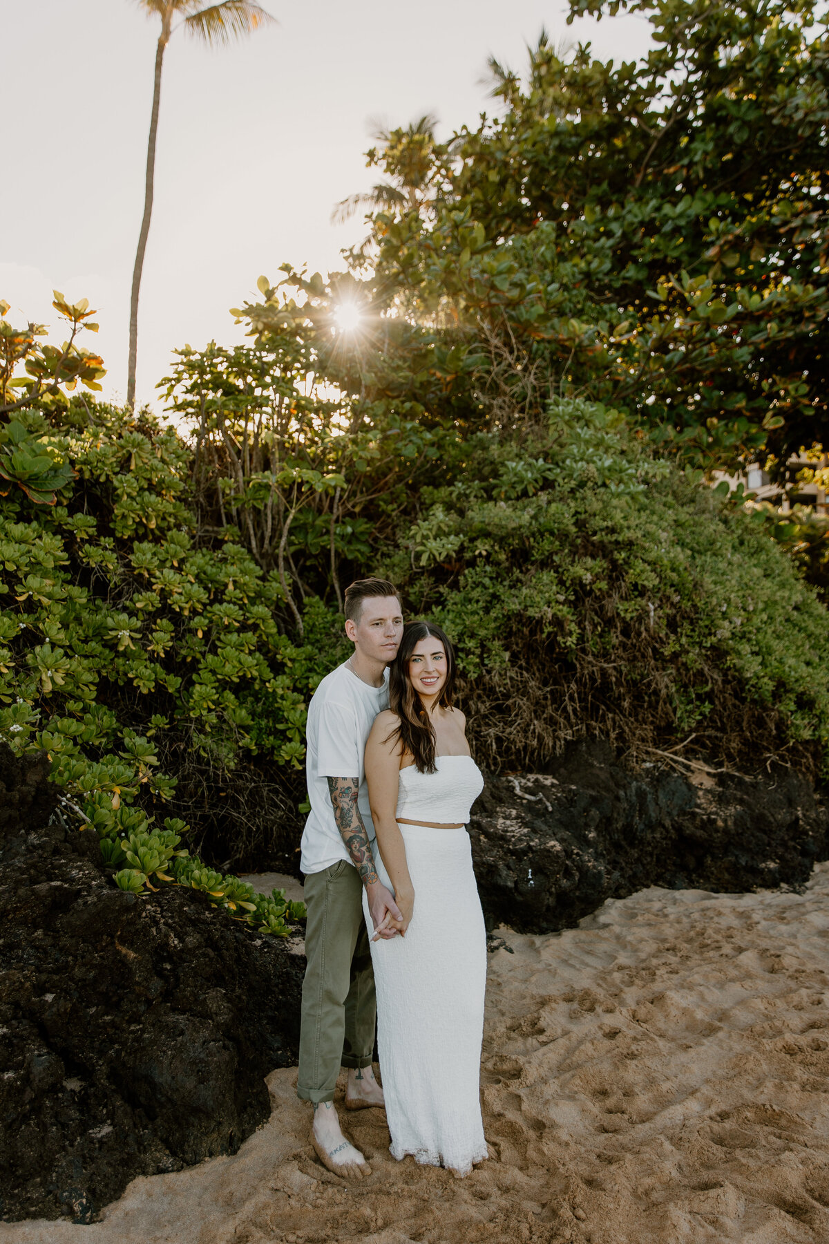 Hawaii Engagement Photographer captures man and woman cuddling on beach during engagements