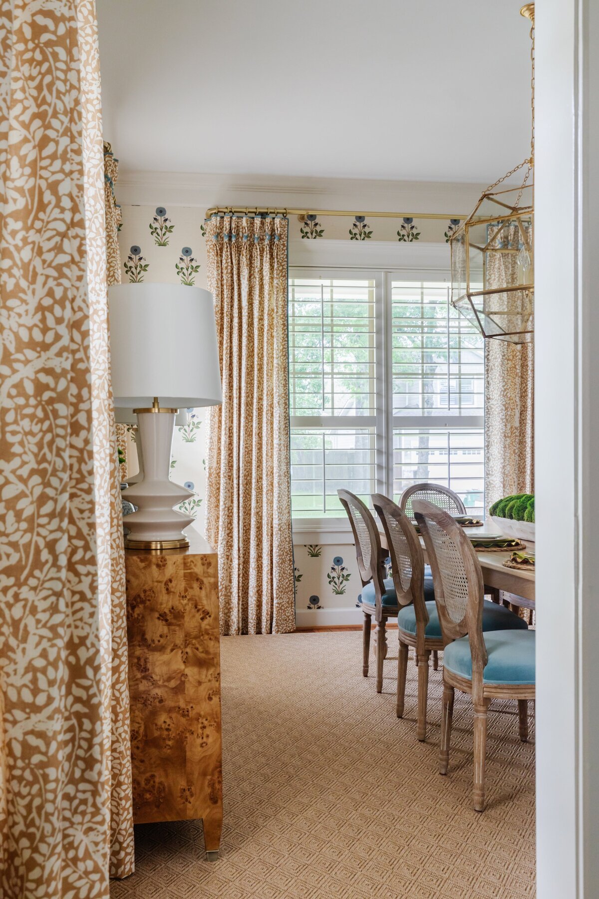 oyster creek studios oak forest remodel wooden side table in dining room with wooden chairs with blue cushiions
