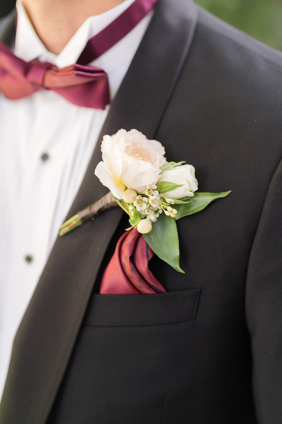 man in a black suit with a flower boutonniere on his lapel