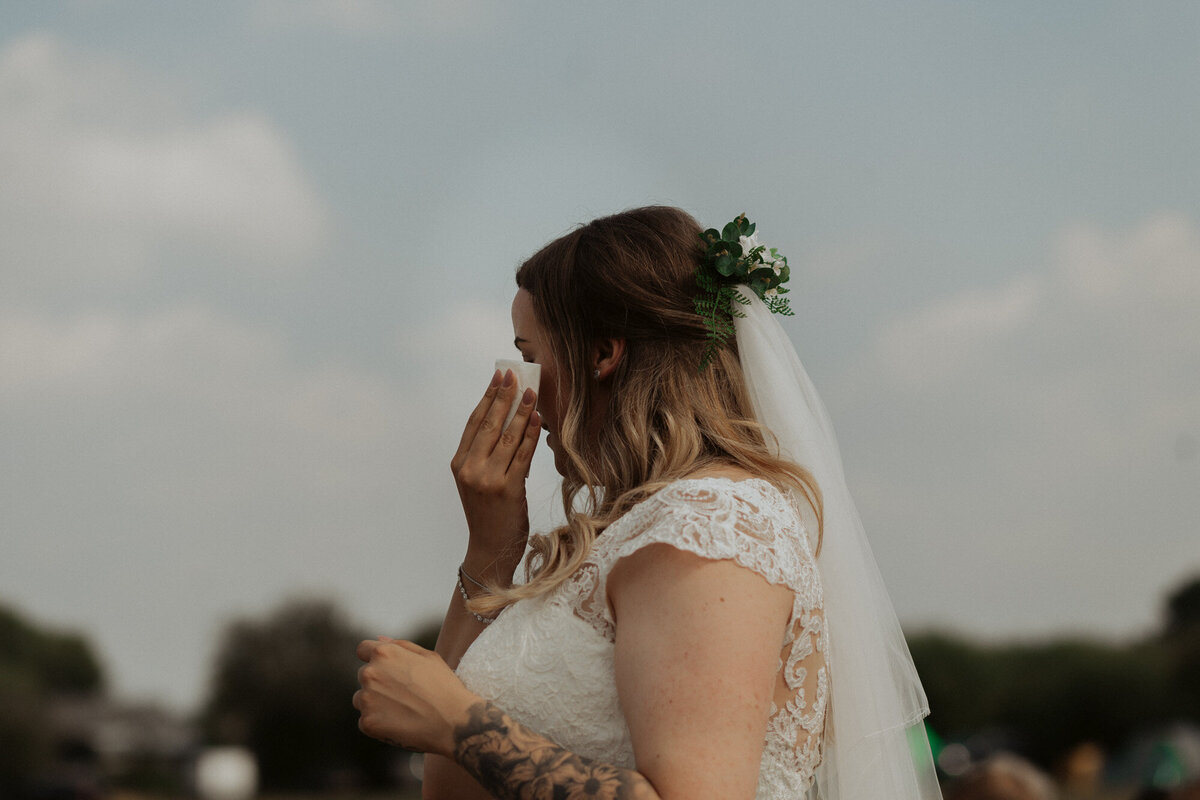 bride wiping tears with tissue