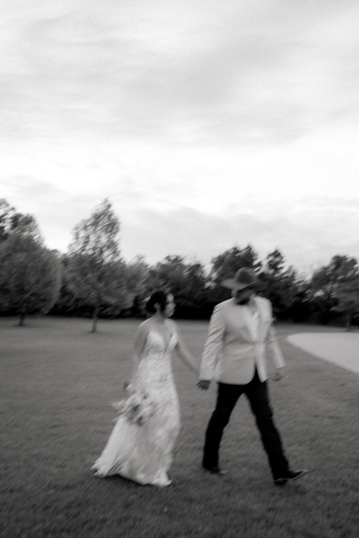 blurry photo of bride and groom walking hand in hand taken by dallas wedding photographer