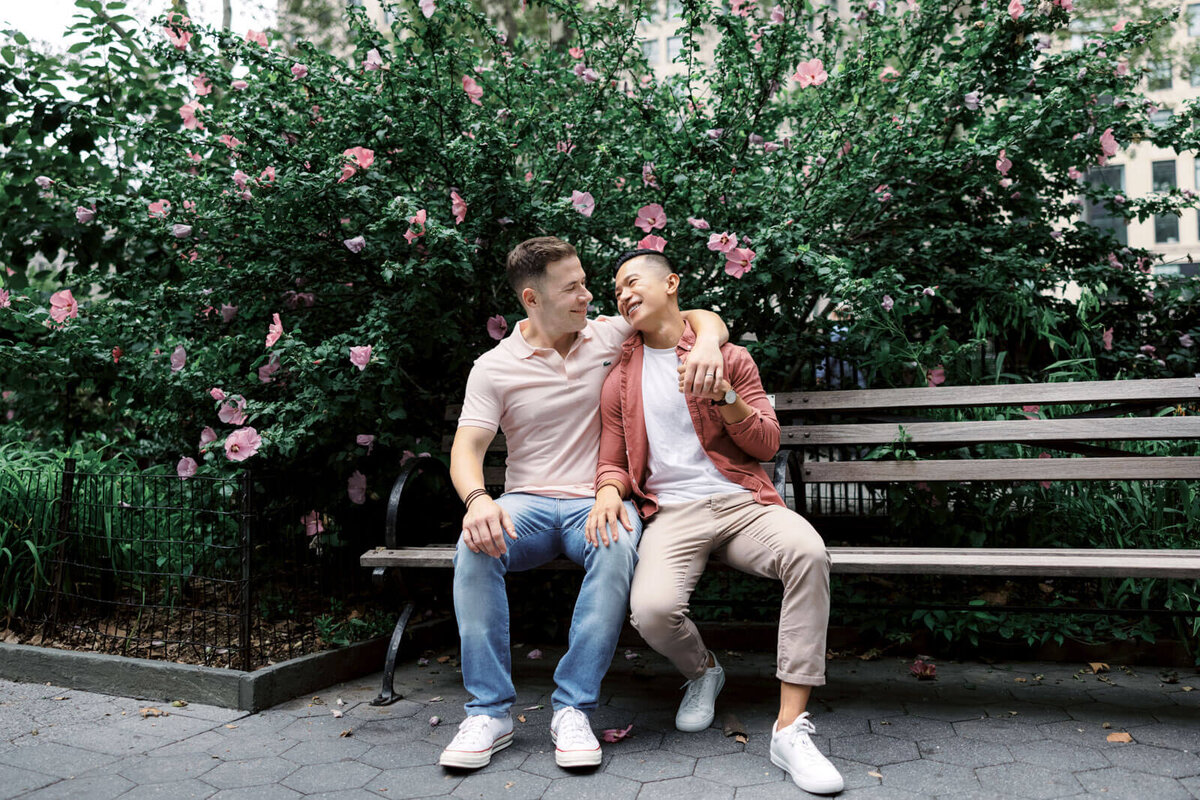 The engaged couple is happily sitting on a park bench in West Village, NYC. Image by Jenny Fu Studio.