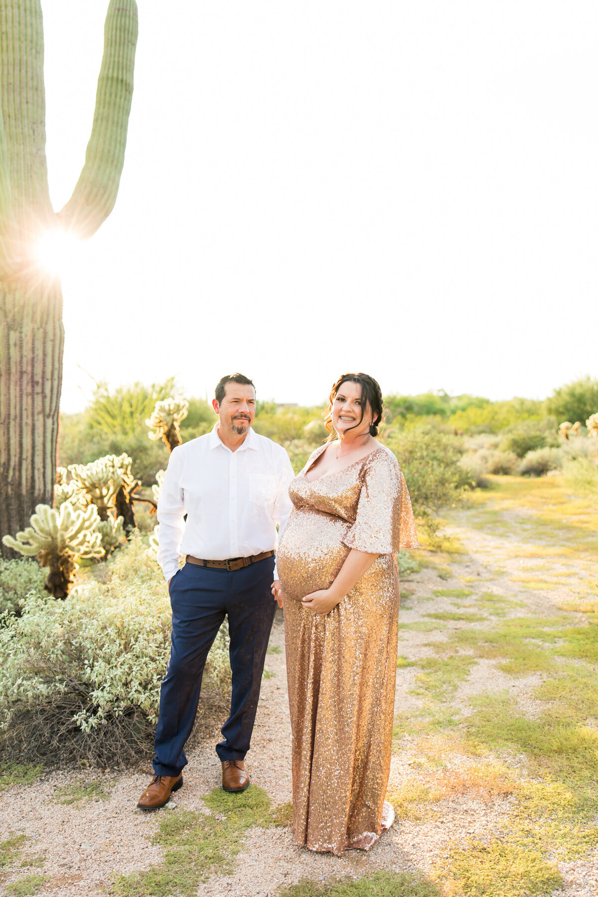 mom and dad to be posing for maternity photo in Scottsdale desert