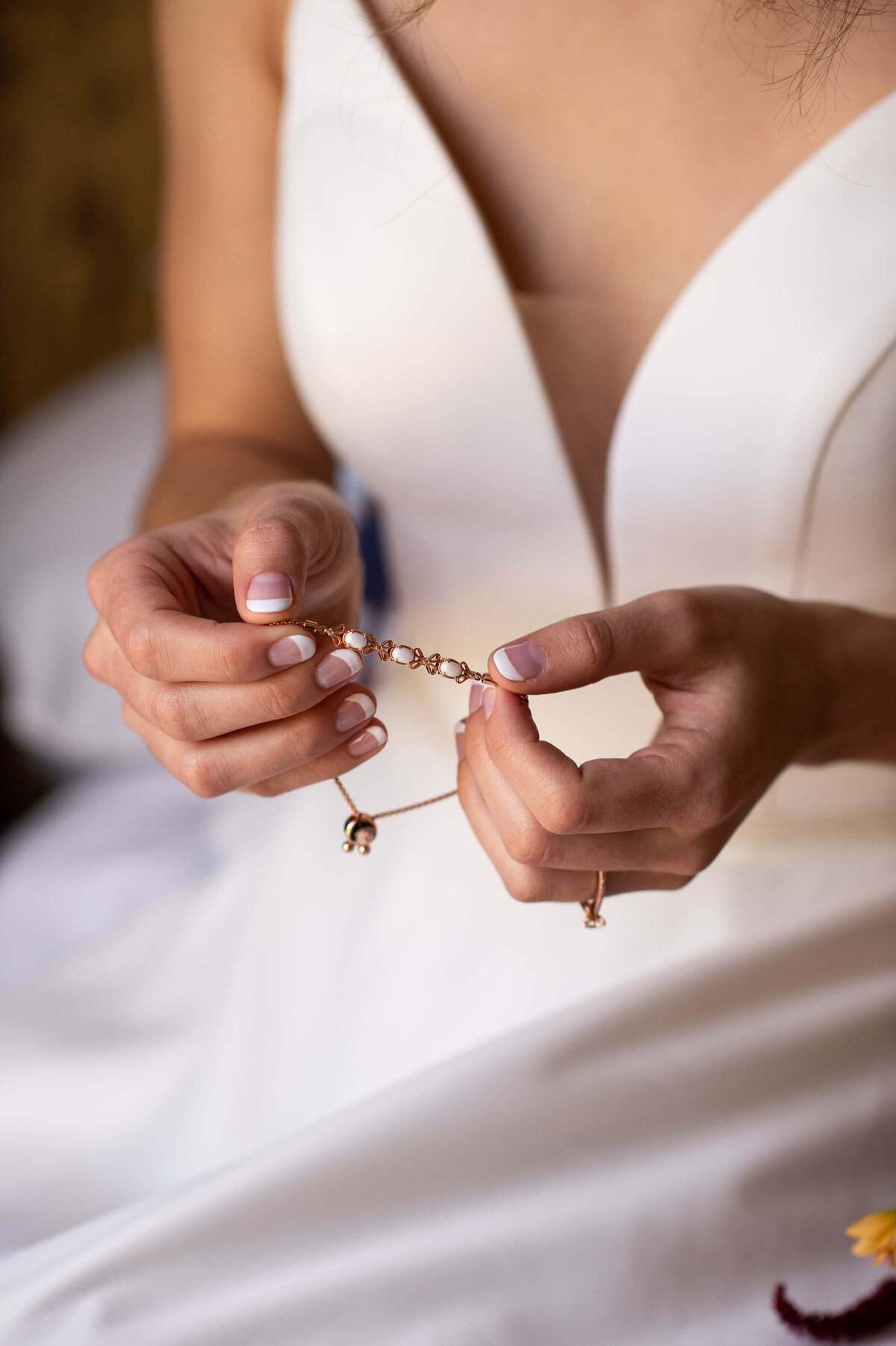 a bride opening up her gift of a rose gold wedding bracelet taken in the bridal suite at Strathmere wedding veune in Ottawa.  Captured by Ottawa wedding photographer JEMMAN  Photography