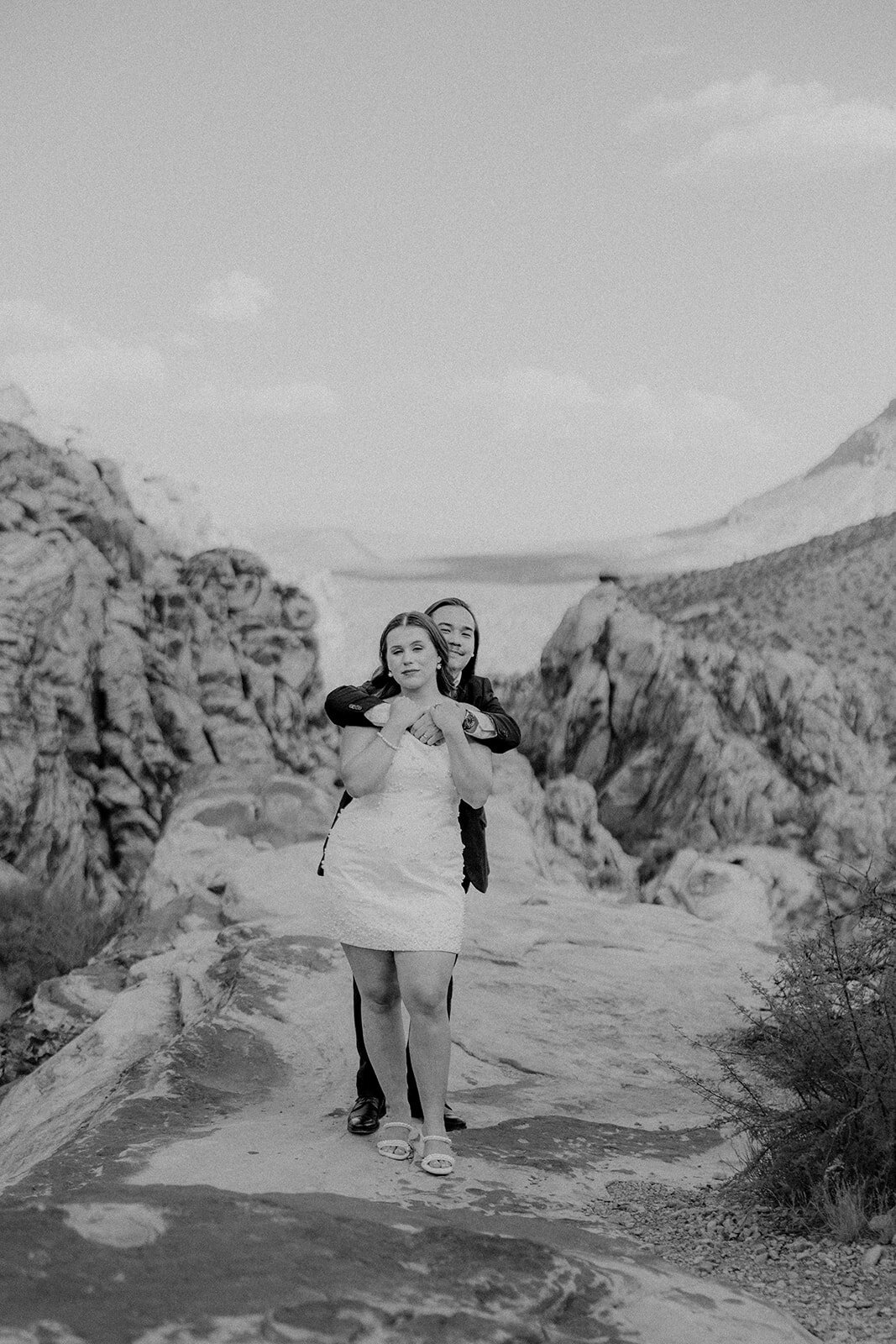 Guy hugging his fiance from behind at the Red Rock Canyon