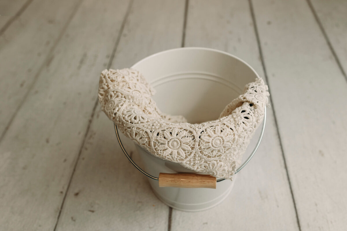 White bucket prop used for newborn photography sessions.