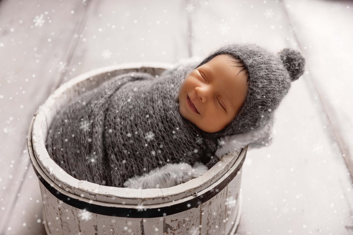 snowing chrisgtmas baby boy in grey and white smiling for his photos in dupont