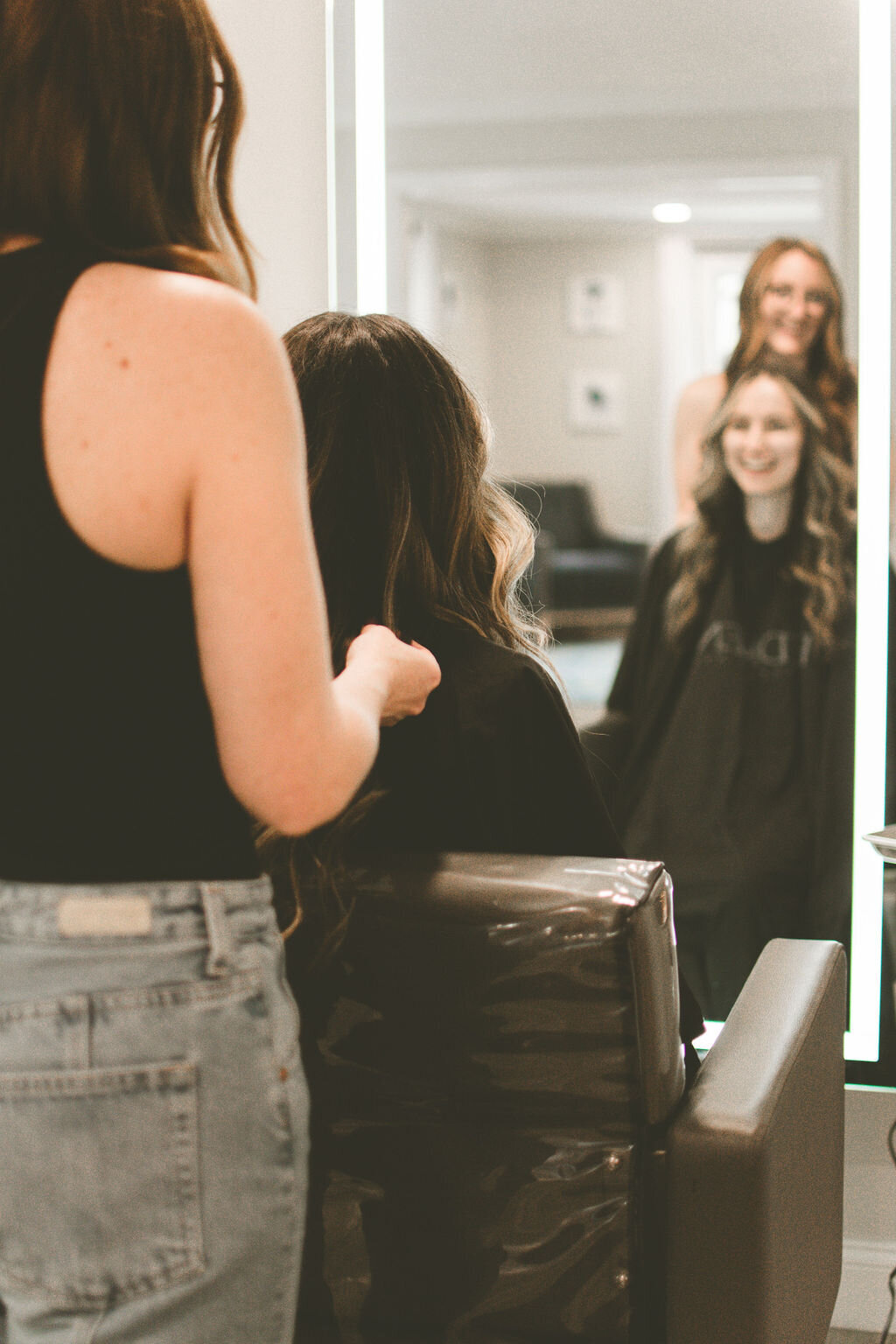 hairstylist laughs with client in chair