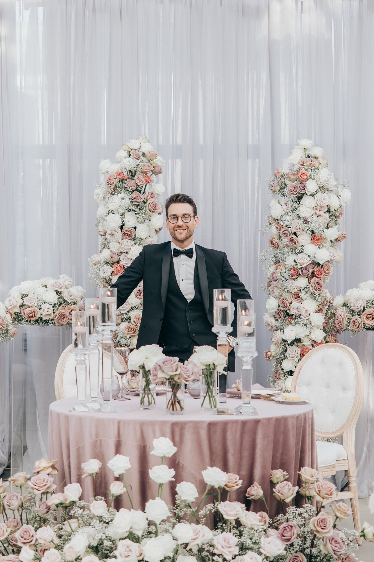 RL Designs wedding designer standing with white and blush roses photographed by Nova Markina Photography