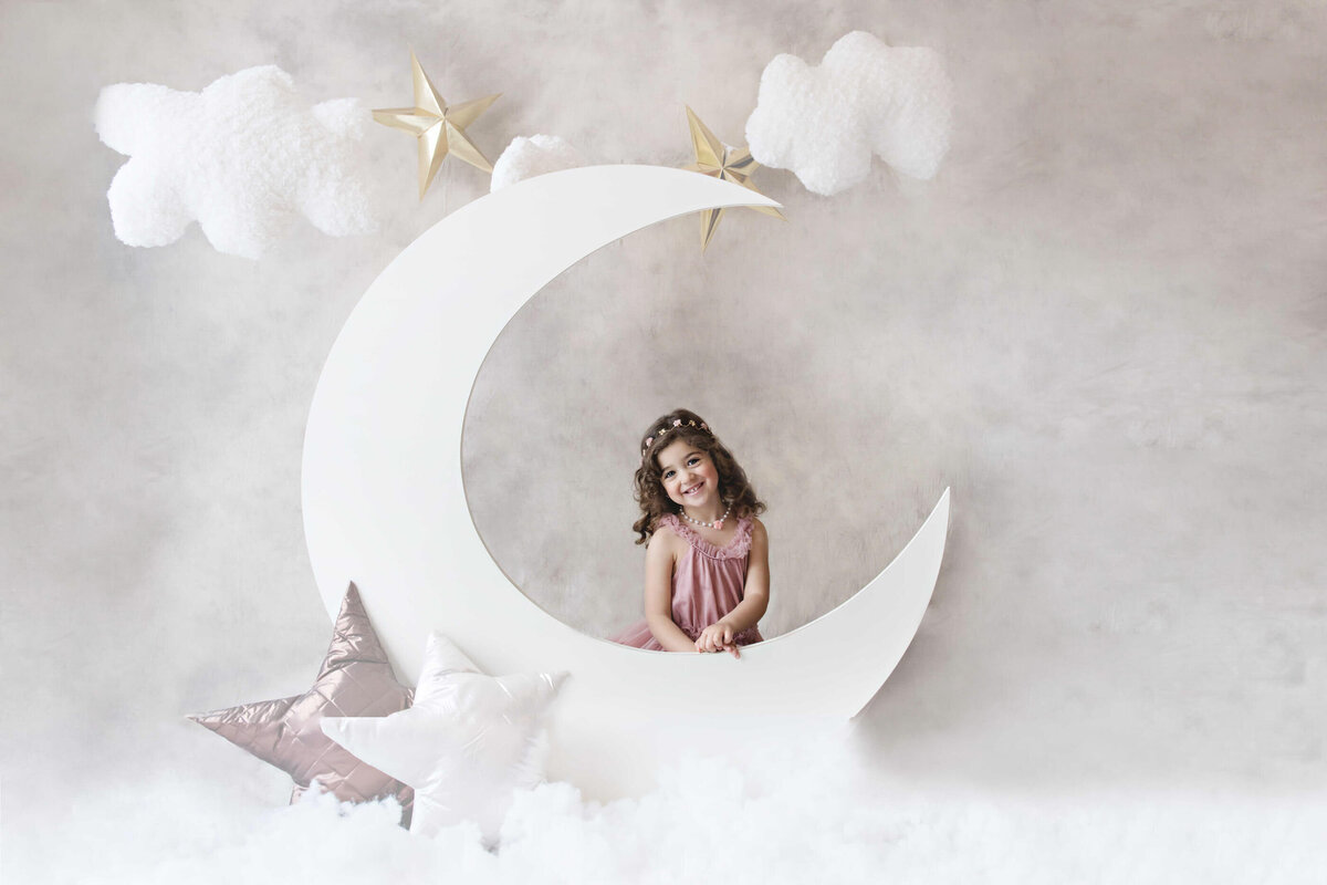 Little girl sitting behind a moon prop for her Kids photos in Burlington, ON