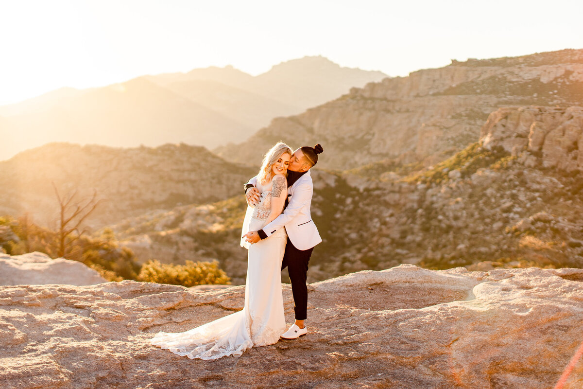 Mount Lemmon elopement photo shoot couple standing with sunset and mountains in background