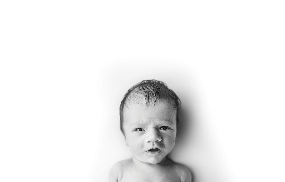 black and white image of baby making silly facial expressions