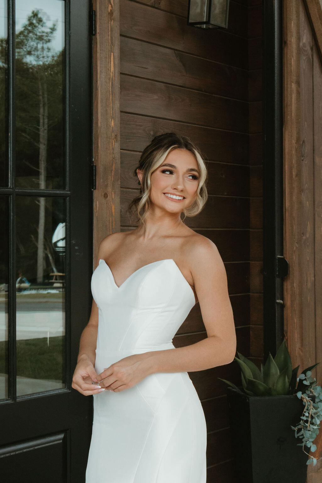 Bride in bridal dress posing outside the reception at The Rosewood Venue in Mount Vernon, TX