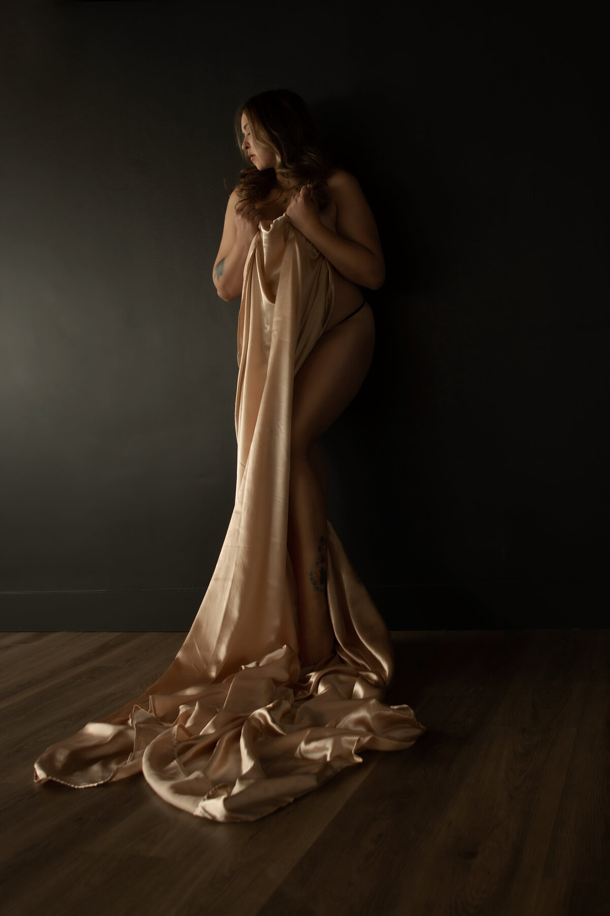 Plus size woman in silk sheets posing for boudoir photos in best vancouver boudoir studio