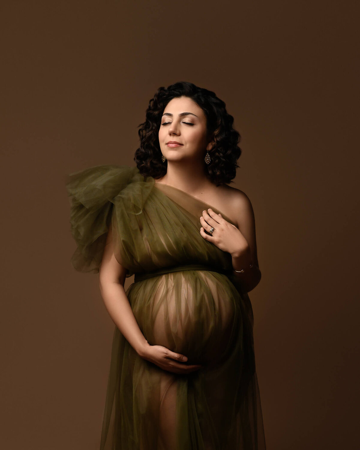 woman wearing olive green tulle one-shoulder maternity dress