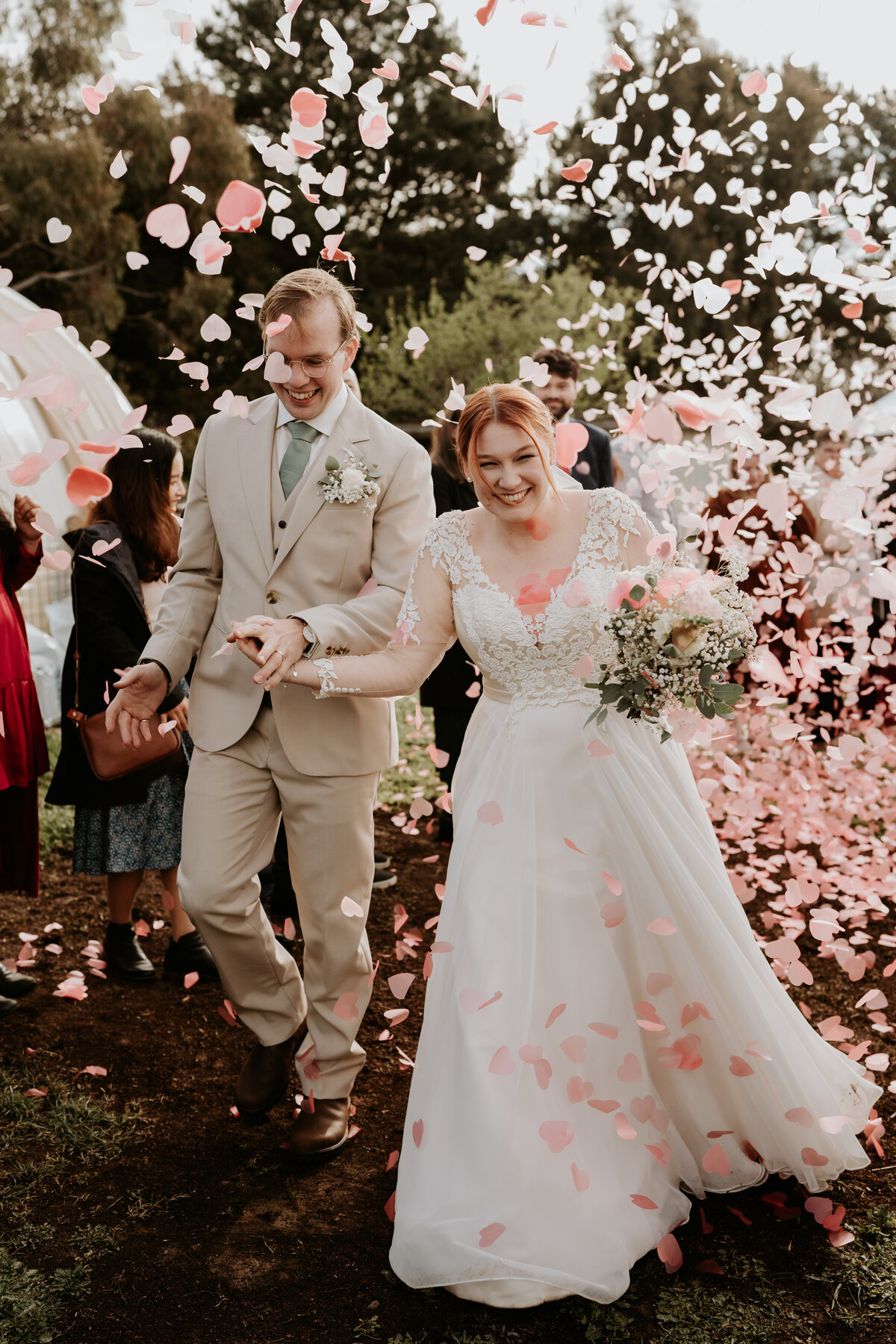 Bride and groom walking down aisle with confetti 