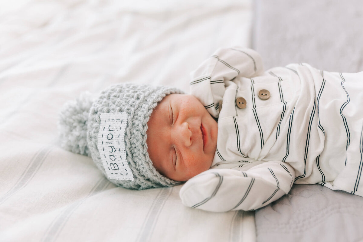 Baby boy wearing a hat and knotted gown during his newborn session