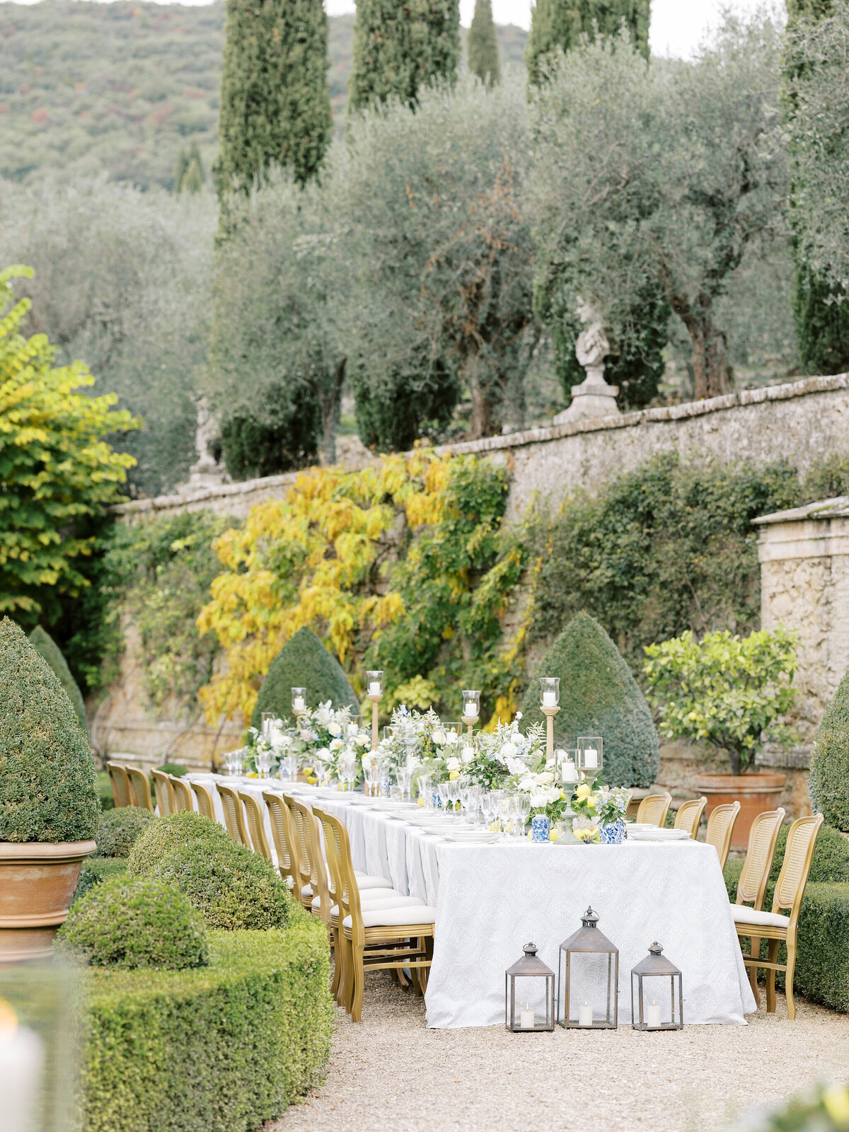 tablescape image with blue and lemon accents in garden of Villa Cetinale in Italy