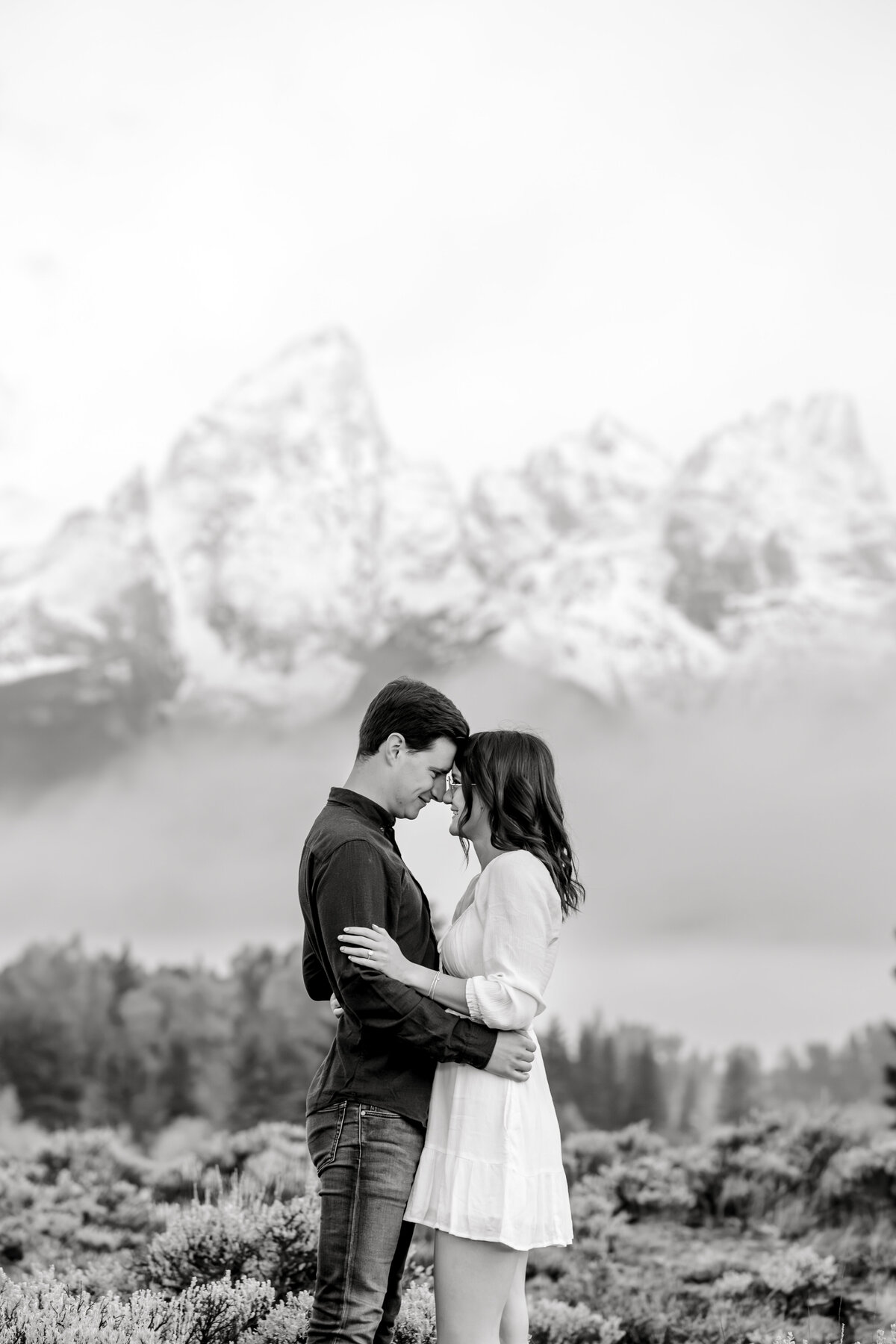 Sunrise photo session of an engaged couple at Schwabacher's Landing in Grand Teton National Park Wyoming with fog and cowboy hats