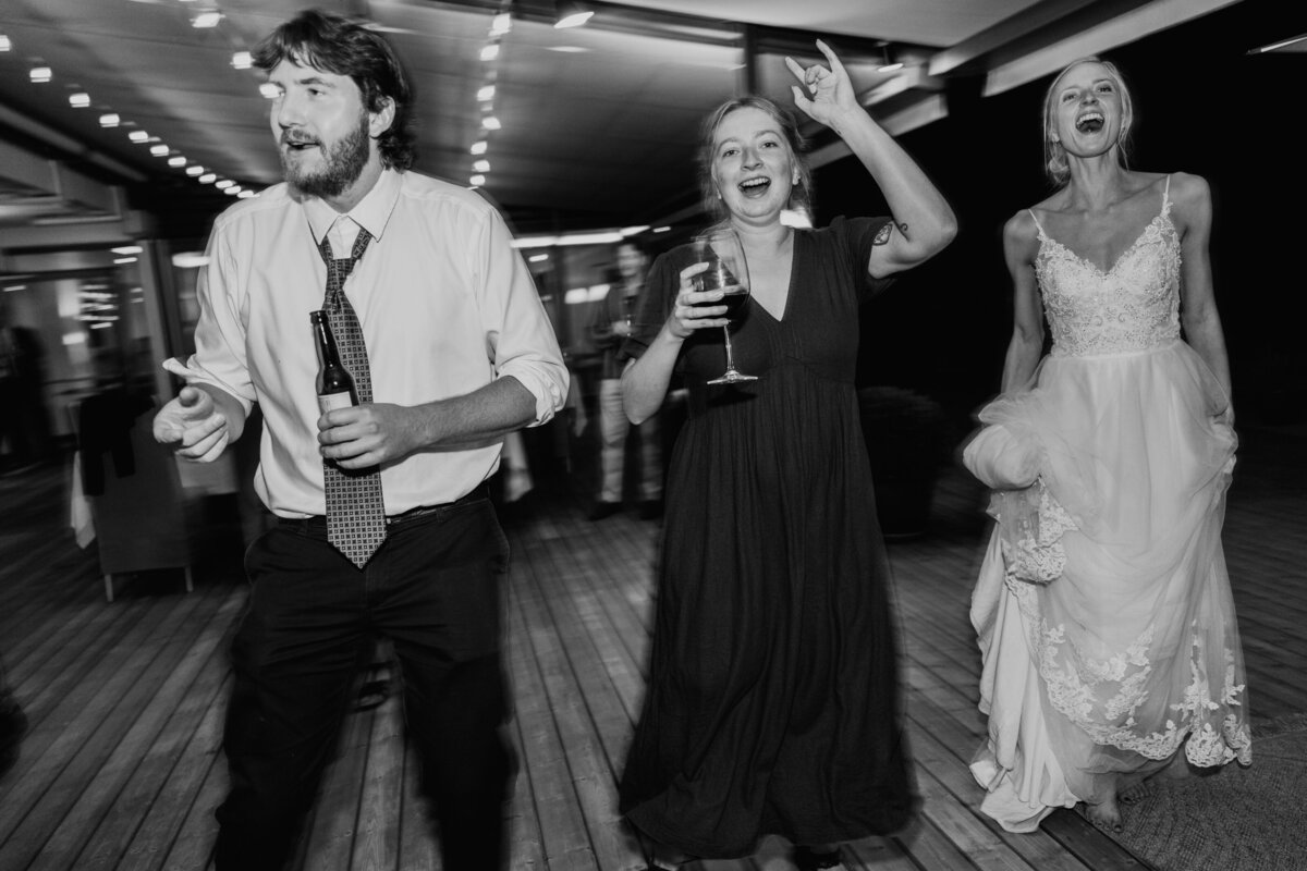 Wedding guests dancing energetically outdoors