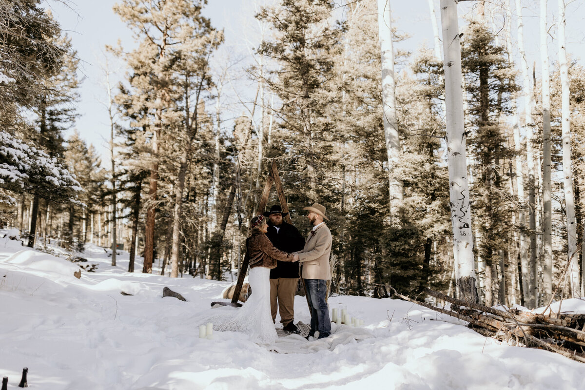 bride and groom standing together in the snow for their elopement ceremony