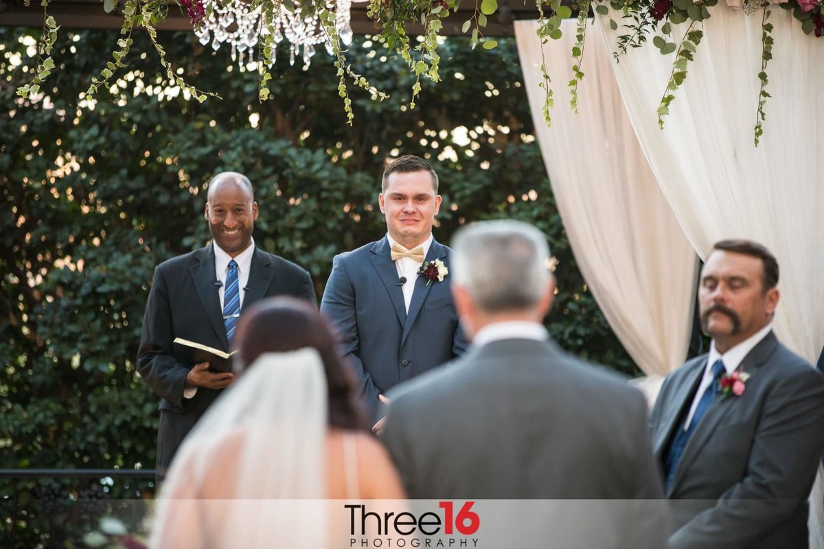 Groom begins to cry as he watches his Bride being escorted to the altar by her father
