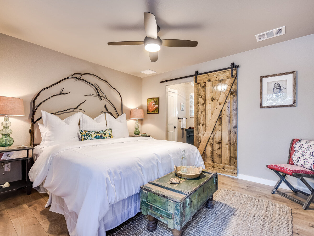 Double bedroom with wooden bed frame, wooden door and red chair