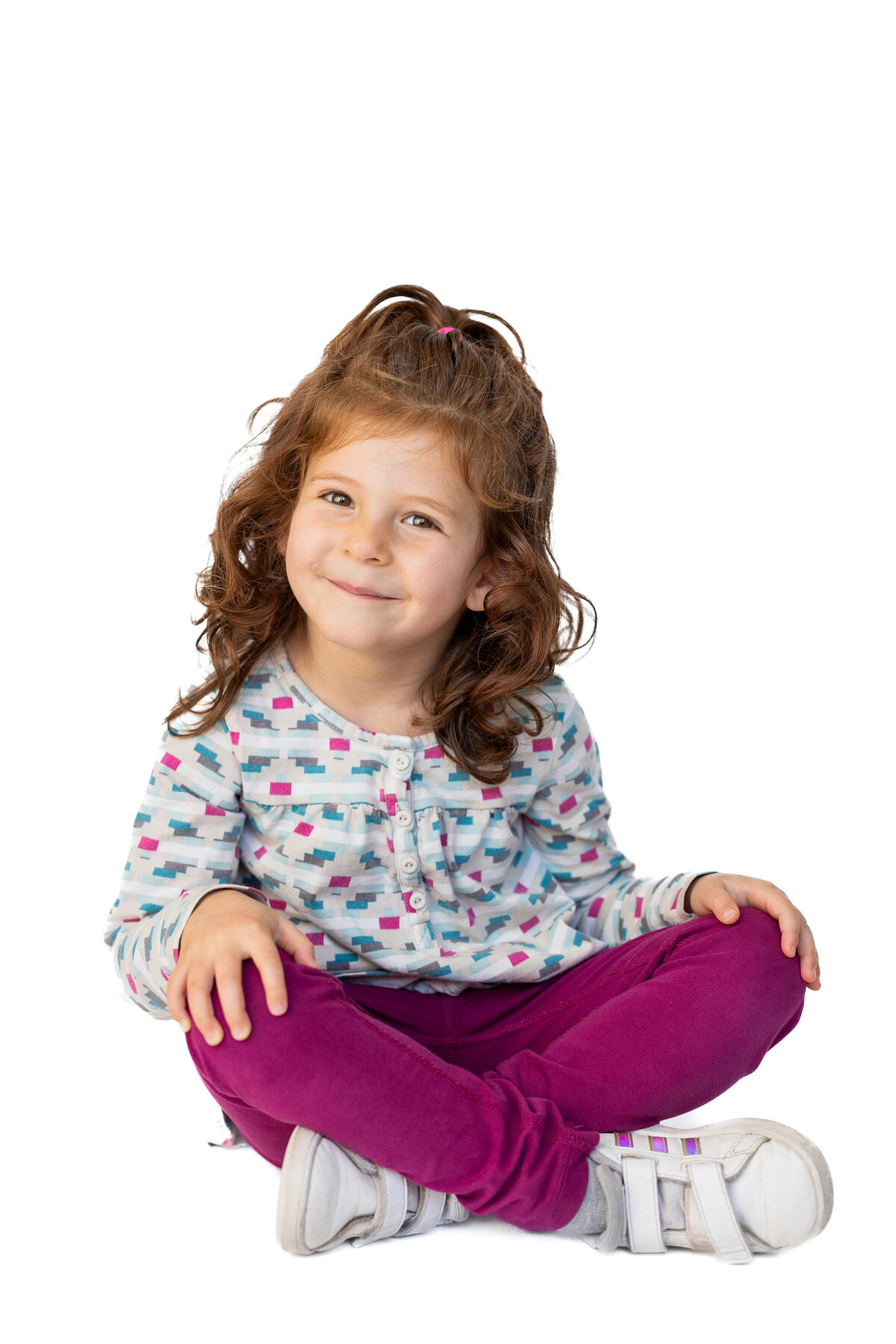 Preschool girl sitting on floor for her school photo