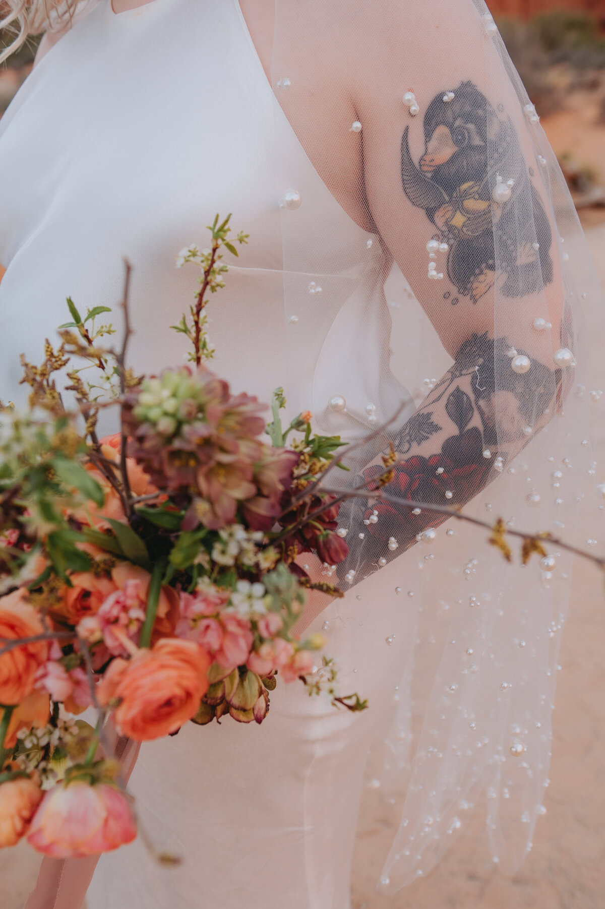 A veil with beads is worn by someone on their wedding day