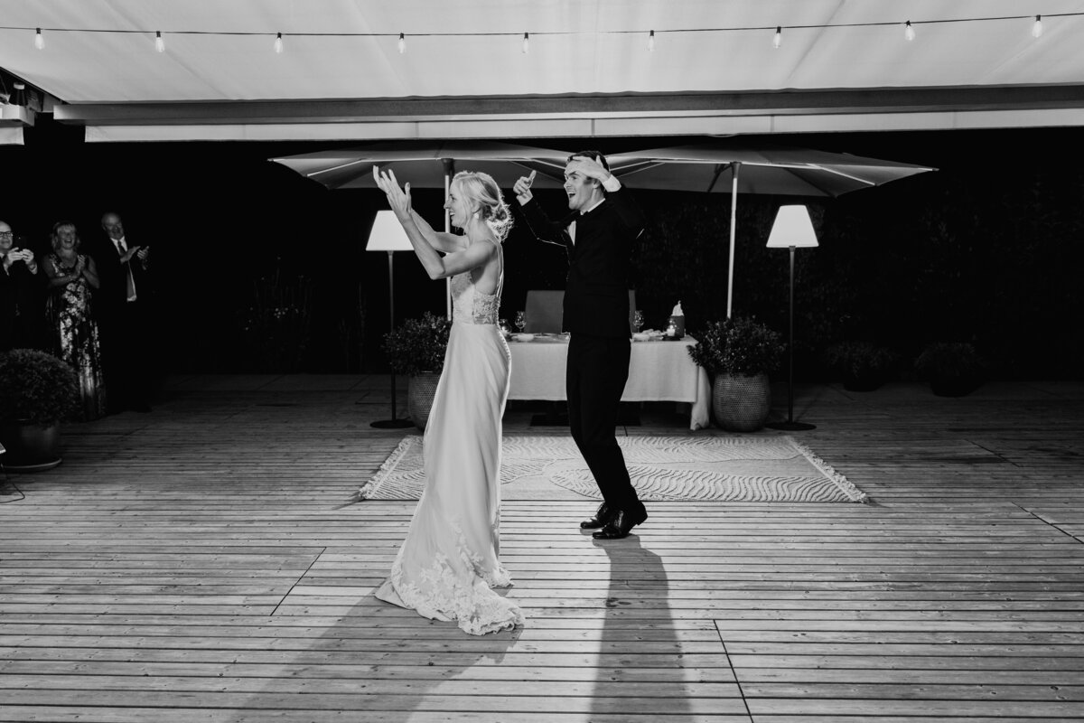 Bride and groom dancing surrounded by friends