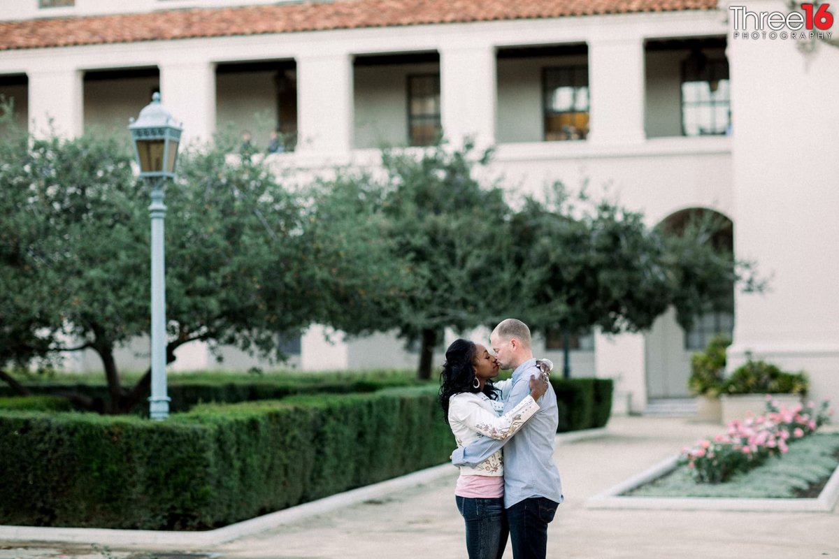 Engaged couple stop for a kiss in the Pasadena City Hall courtyard
