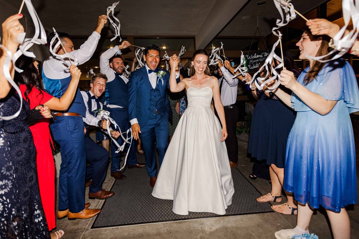 Bride and groom, leaving a wedding at Lake Wilderness Lodge with a streamer exit