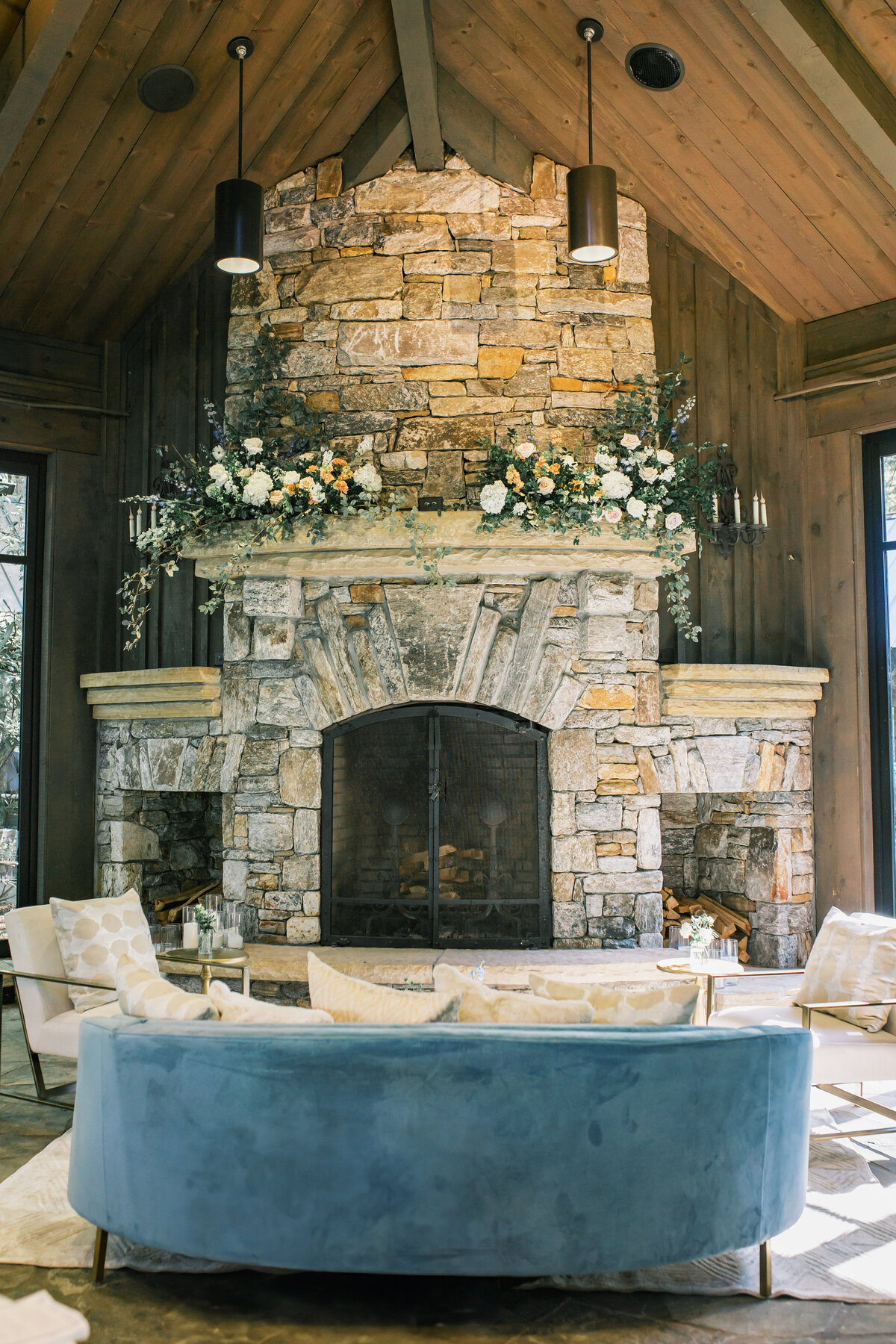 Lush floral installation on stone fireplace mantel at Old Edwards Inn wedding reception in Highlands, North Carolina.