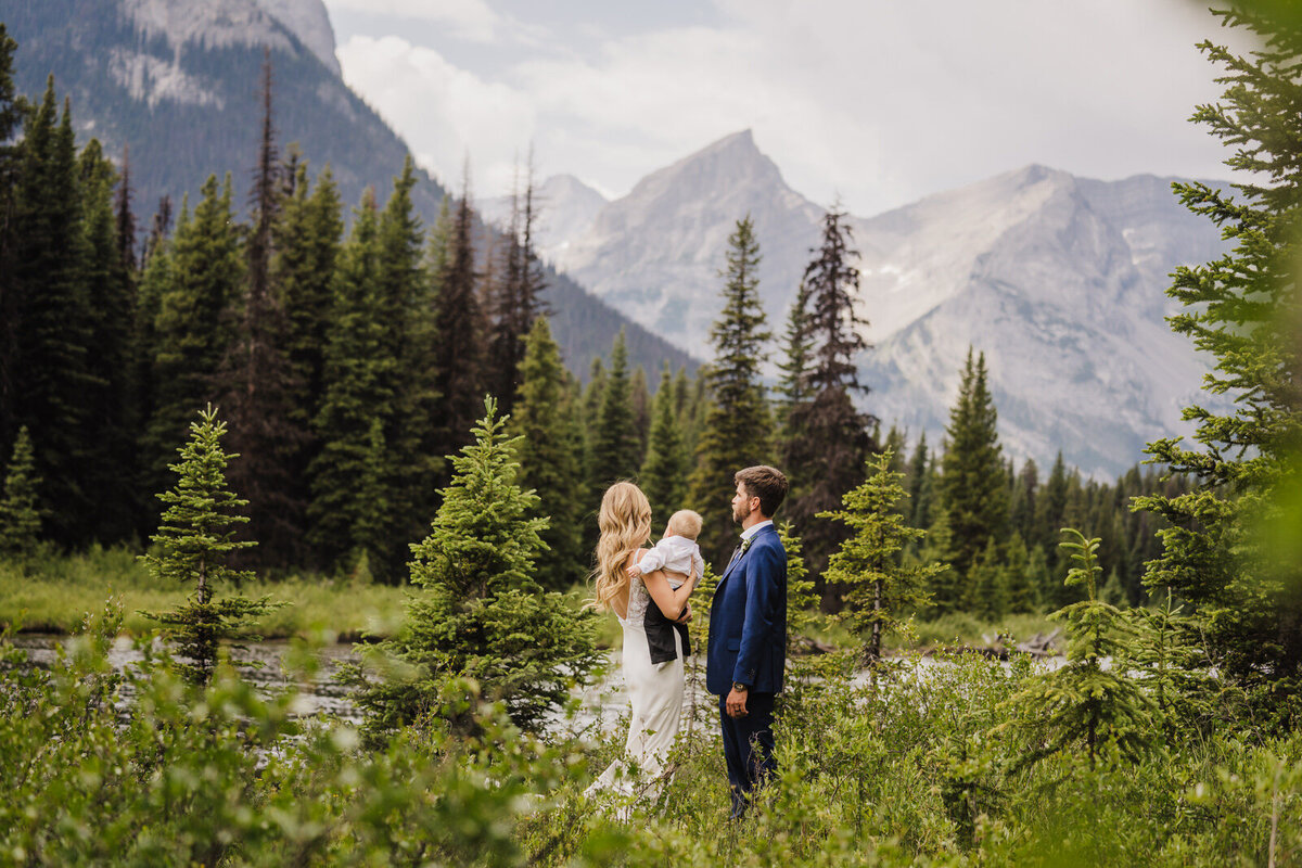 bride and groom walking across mountain scape