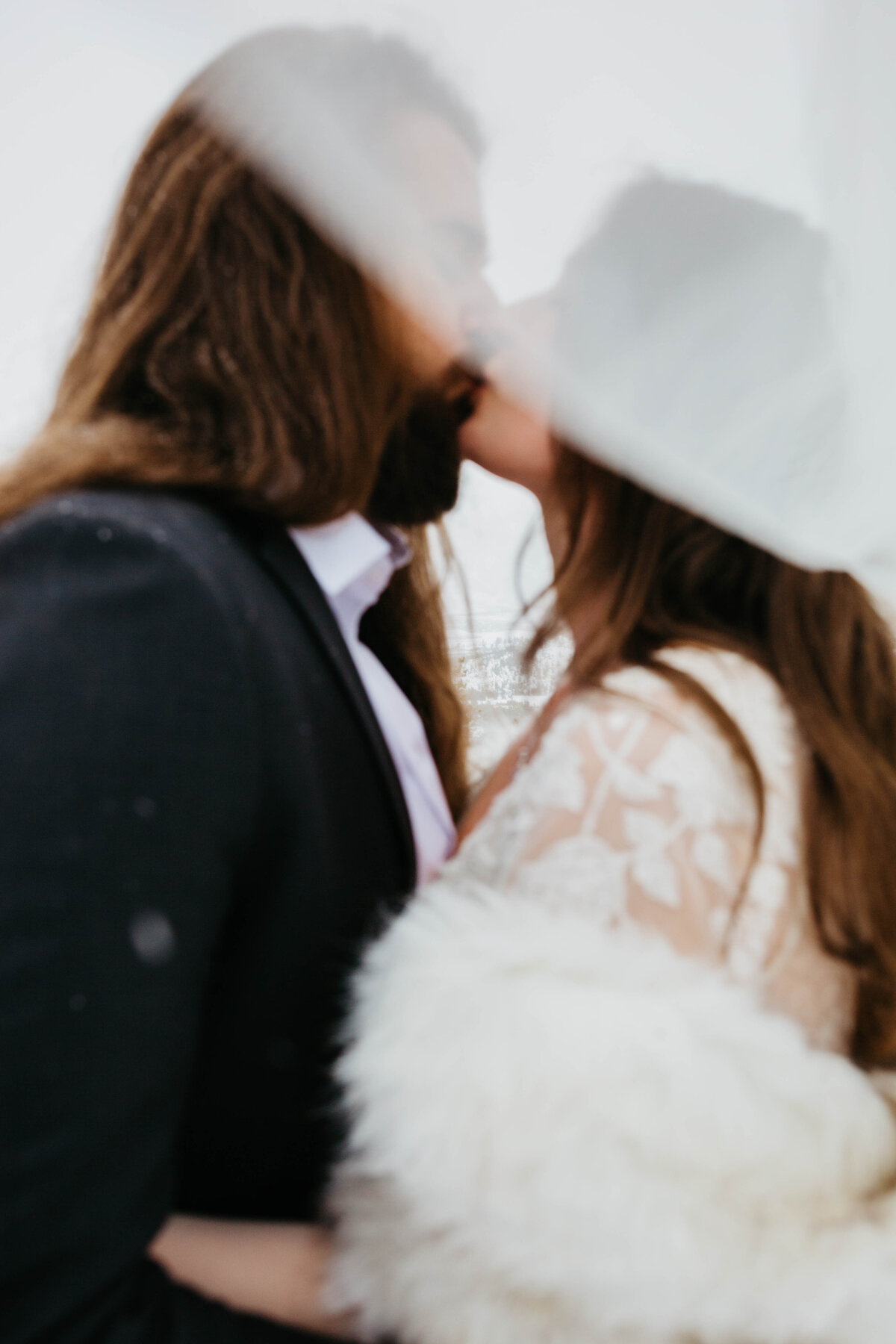 bride-and-groom-kissing-under-veil