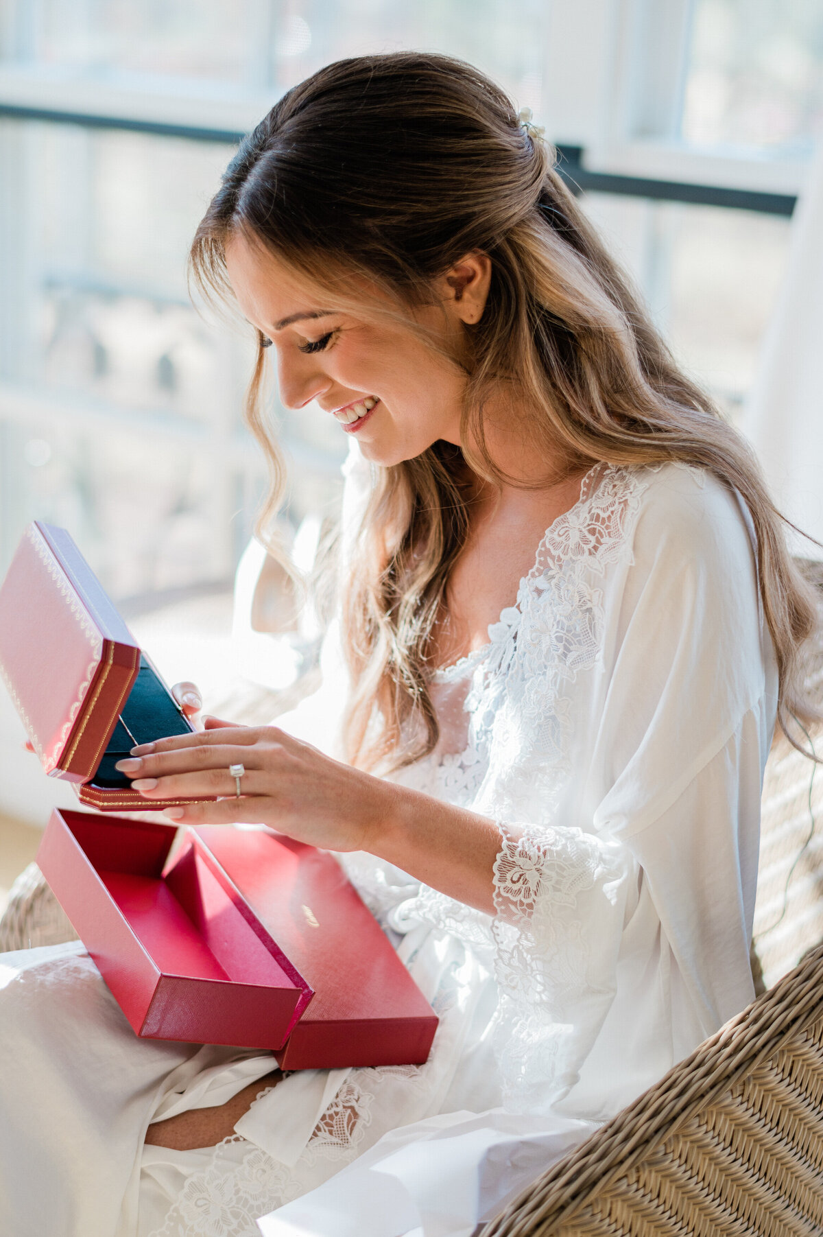 Bride smiles and opens a gift from the groom 