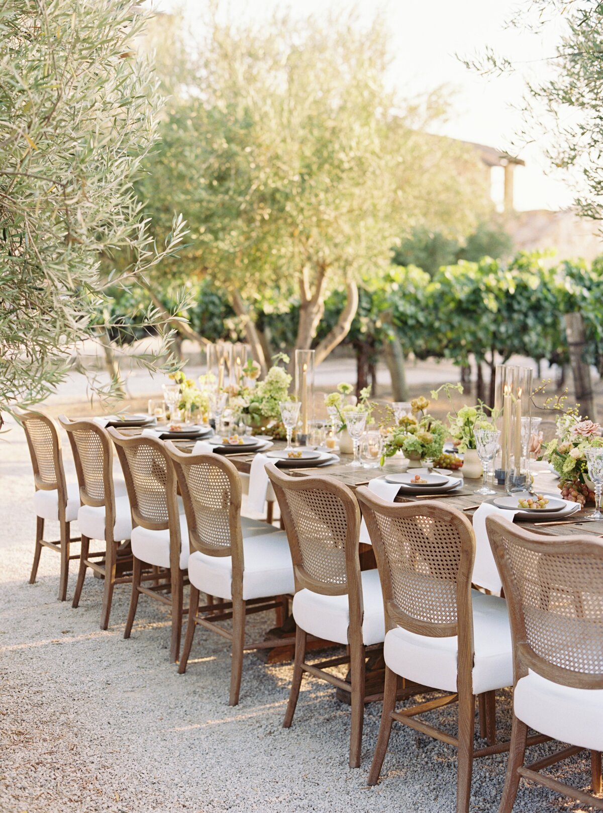 outdoor wedding reception table setting with wicker chairs
