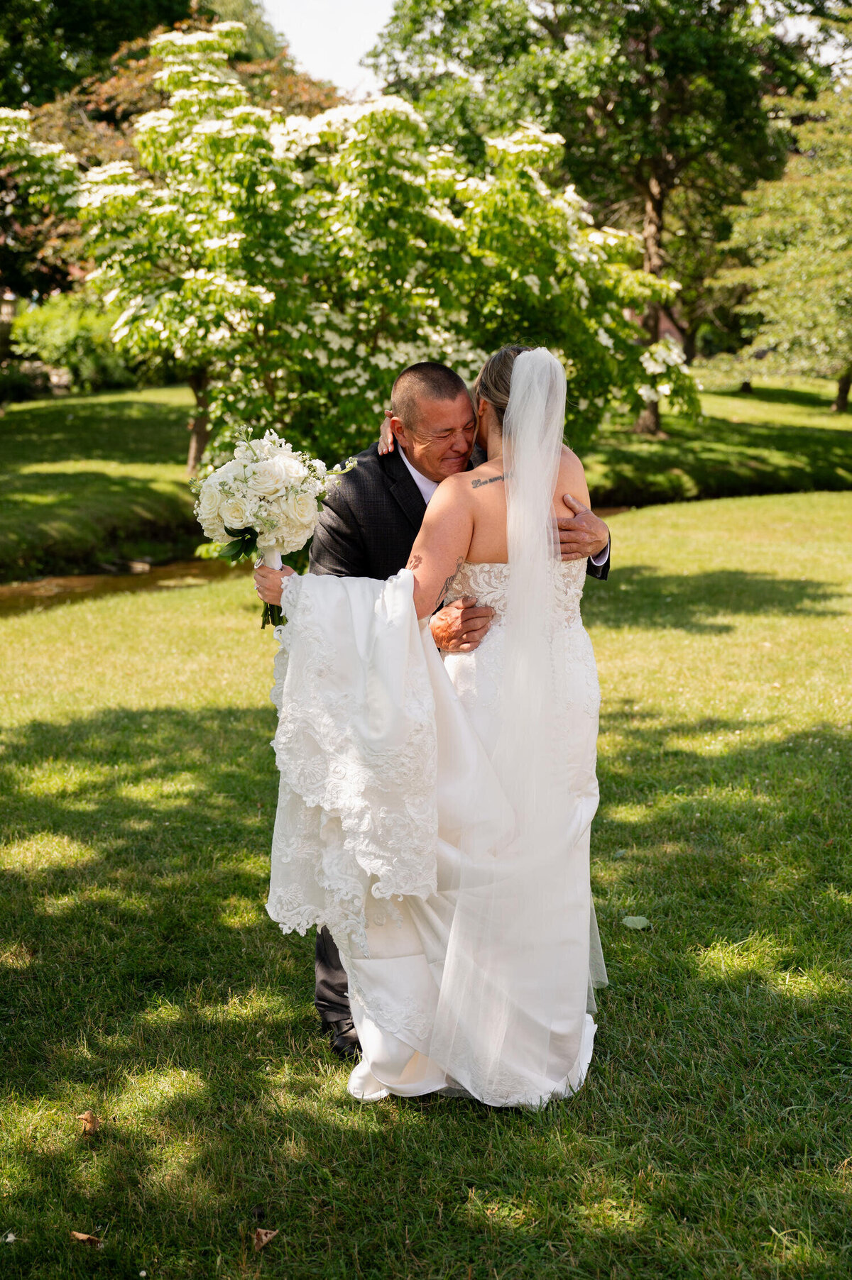 An emotional first look between the bride and her dad in Congress Park before her wedding at the Canfield Casino in Saratoga Springs, NY.