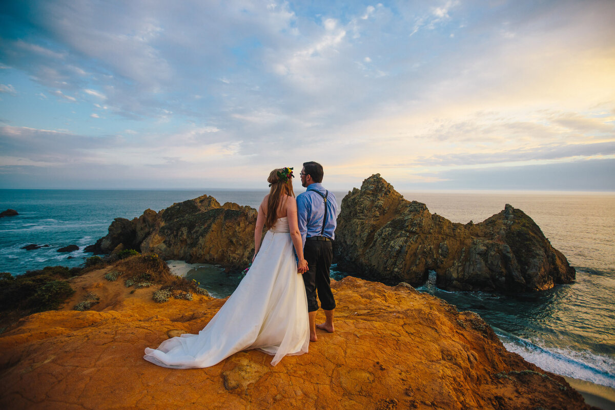 Bride and groom overlook cliff during their adventure elopement in California Bay area