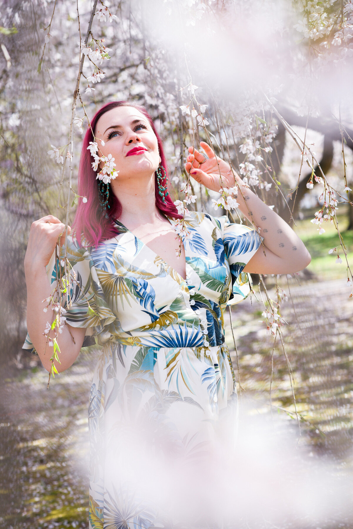 A person looking up while standing under a tree with vines coming down