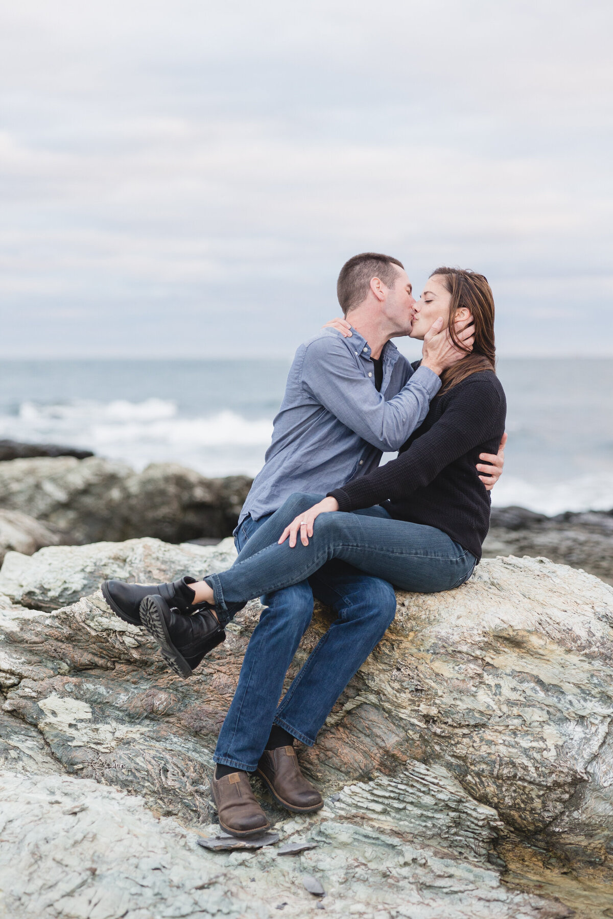Couple kiss as the waves crash behind them in Newport RI